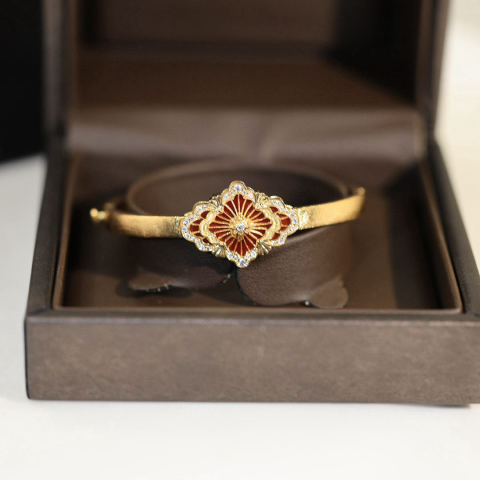 Buccellati, an Italian high-end jewelry brand, presents a vintage-style, courtly-inspired, diamond-encrusted, brushed four-leaf clover, seashell, agate, and chalcedony double-sided bracelet.