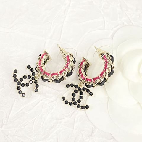 Chanel black and gold leather earrings with contrasting hooks and double C logos.